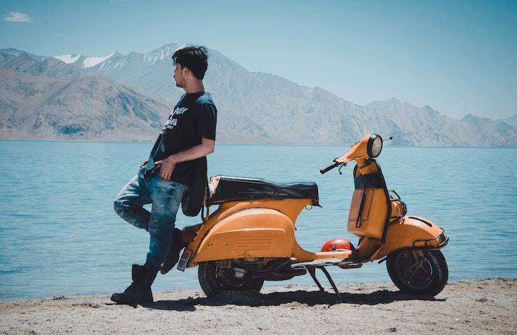 Ragazzo appoggiato a uno scooter